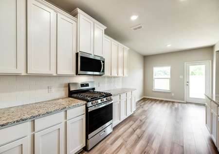 The kitchen is open to the dining room and offers beautiful, white cabinetry.