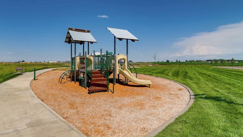 Hidden Valley Farms children's playground area with open grass field around it.