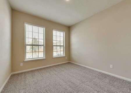 Erie secondary bedroom with two large windows and carpet