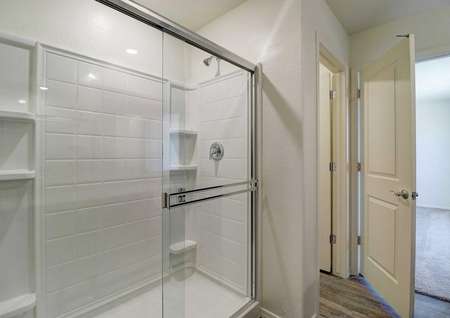 The walk-in shower with a glass sliding door in the Guadalupe floor plans master bathroom.
