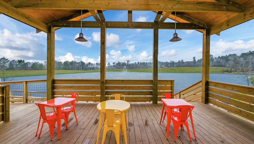 Wedgewood Forest fishing cabin deck with seating overlooking the lake and fountain during daytime