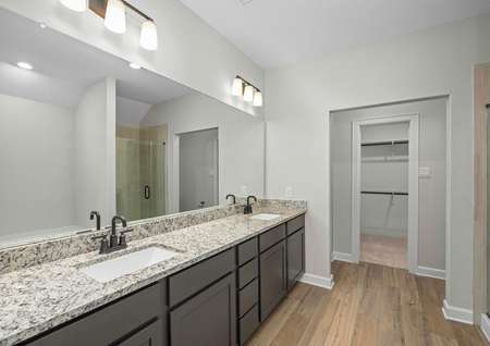 Master bathroom with a dual sink vanity, step in shower, and a soaking tub