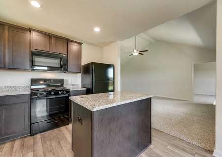 Sabine kitchen and living room with granite counters, island, and modern black appliances
