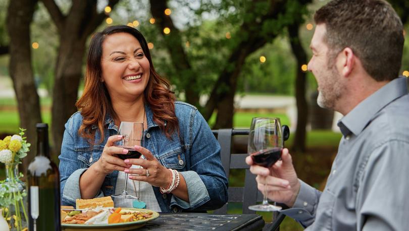 Woman laughing with wine in hand.