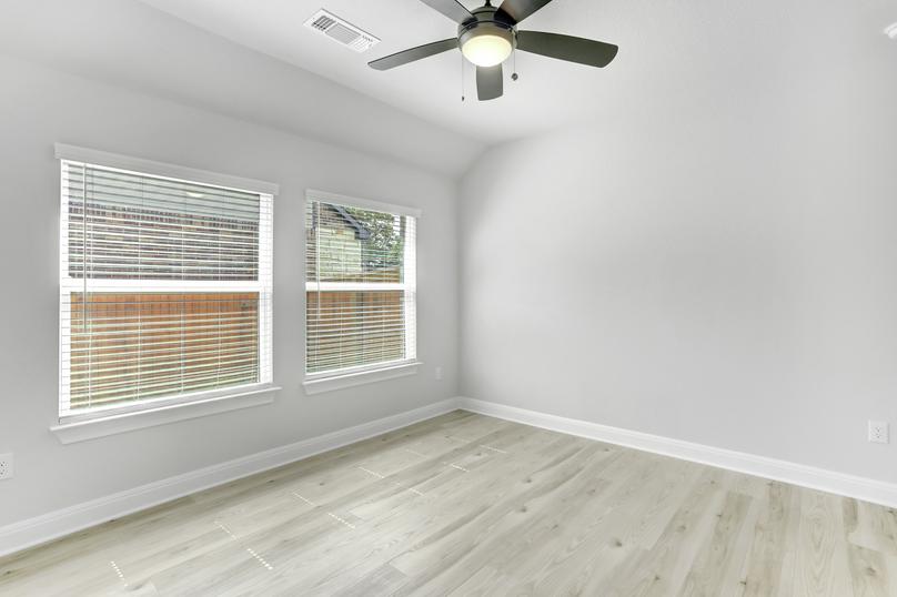 Flex room with large windows, wood flooring, and a ceiling fan.