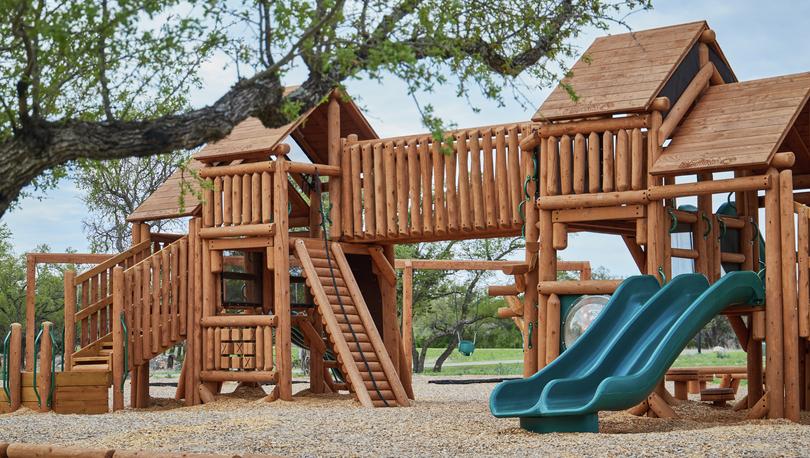 Rustic children's playground at Spicewood Trails.