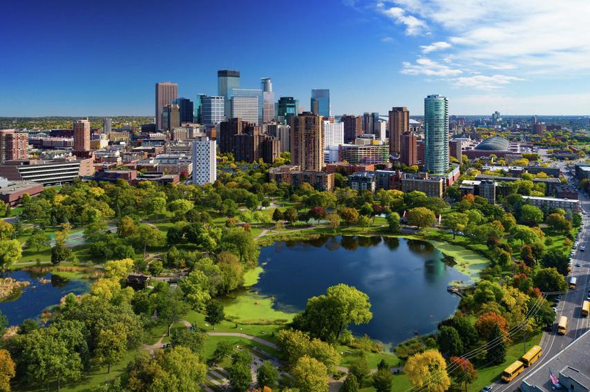Minneapolis, Minnesota downtown cityscape showing park with ponds, green grass and paths, and plenty of trees