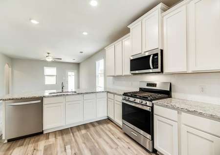 The kitchen is highlighted by beautiful, white cabinetry and granite countertops.