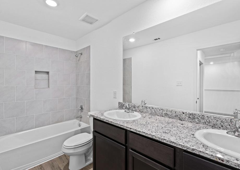 Secondary bathroom with a double-sink vanity, granite countertops, and espresso cabinets.