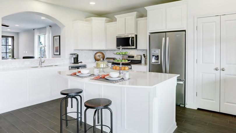 The kitchen of the Timberlake has white cabinetry and dark flooring.