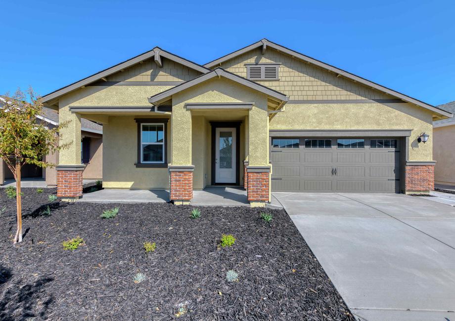 Cooley finished home street view with landscaped yard, two-car brown garage door, and yellow finish