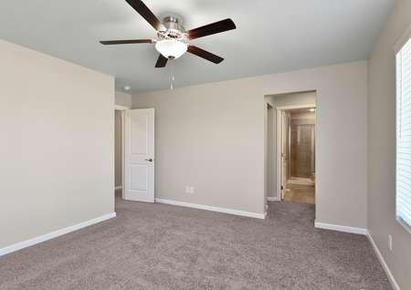 Master bedroom with a ceiling fan and carpet