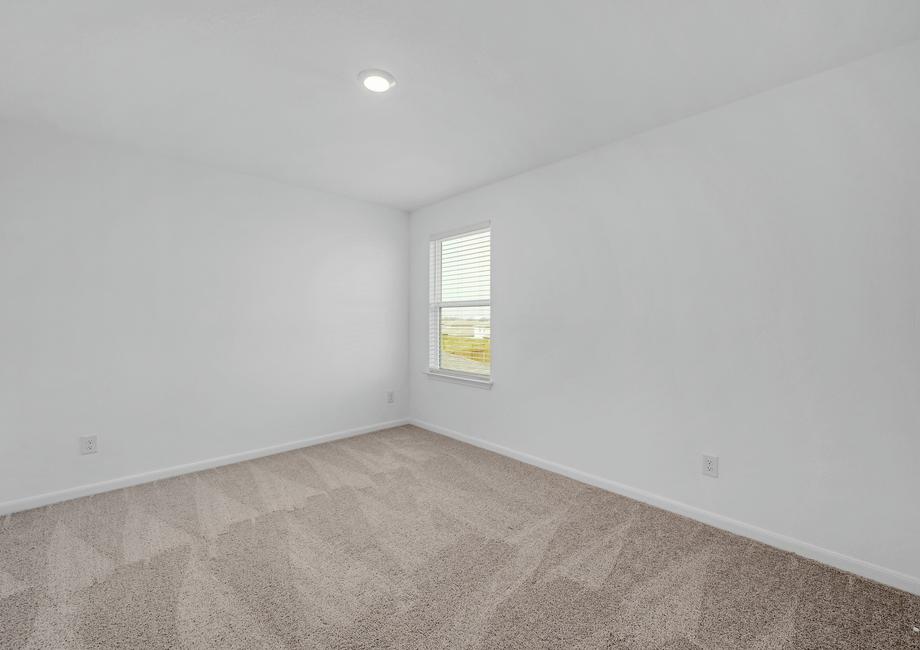 Secondary bedroom with a window, recessed lighting, and tan carpet.