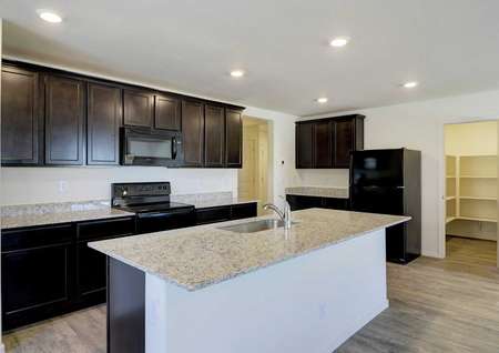 The kitchen in the Picacho floor plan with recessed lighting, a pantry, an island and wood-like flooring.