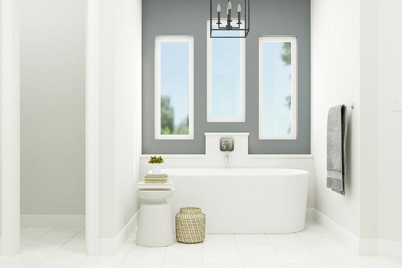 Rendering of the master bathroom centered
  on the freestanding bathtub. Above the tub are three windows letting in ample
  light and an elegant chandelier.