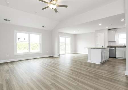 Photo of a spacious living room, kitchen and dinette with plank flooring.