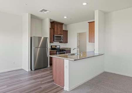 The kitchen has stainless steel appliances and plank flooring. 