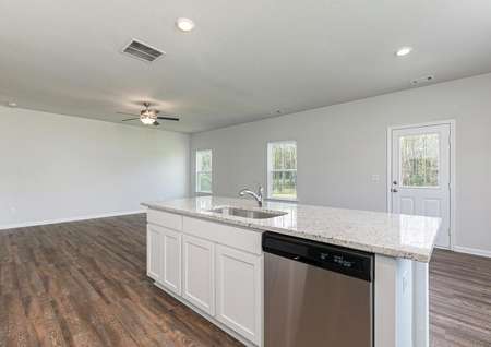 The kitchen island is spacious and overlooks the dining and family rooms