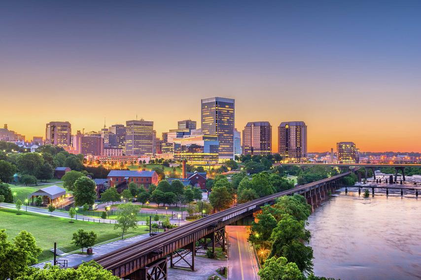 Richmond, Virginia downtown skyline at dusk with trainline, city park, and river water