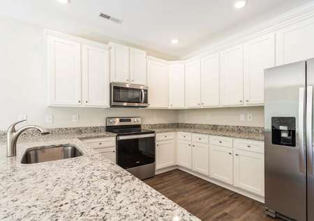 Fantastic kitchen with stainless steel kitchen appliances, granite countertops,white cabinetry with hardware and vinyl flooring.