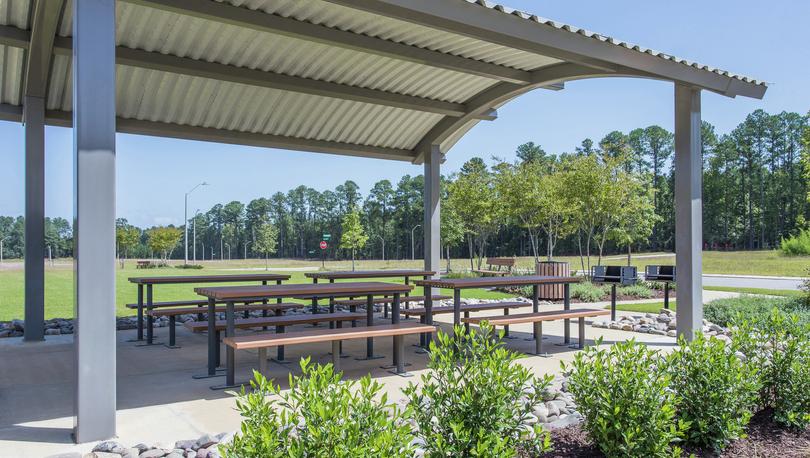 Shaded pavilion with picnic tables and grills.