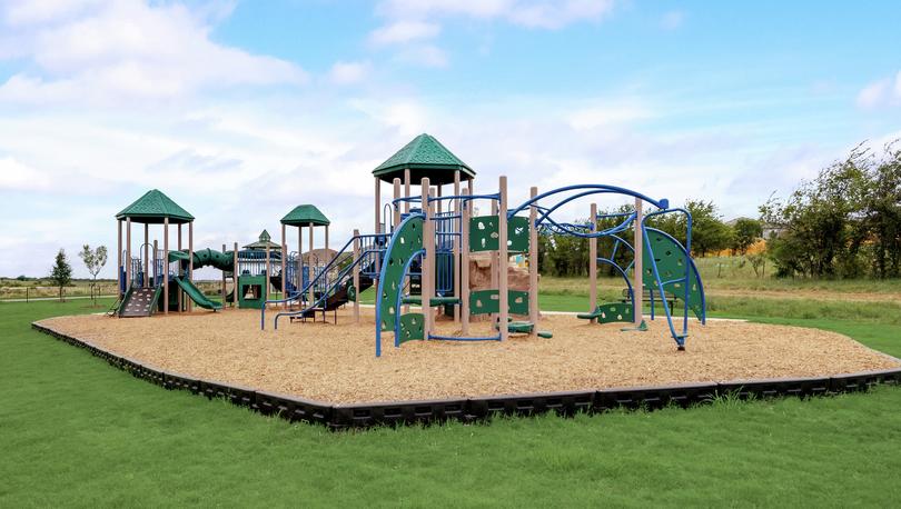 Children's playground at Chisholm Springs with multiple play structures.