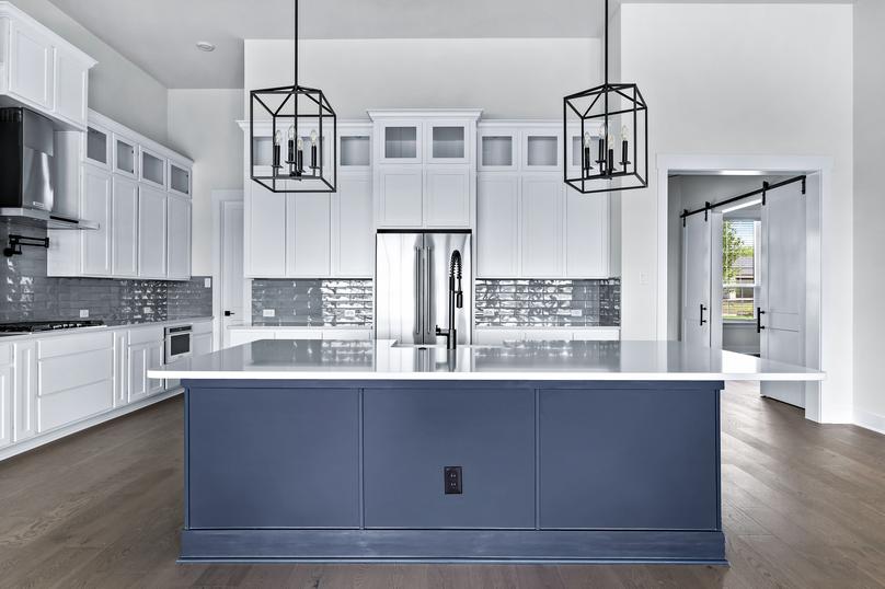 Designer kitchen with an oversized island and stunning light fixtures.