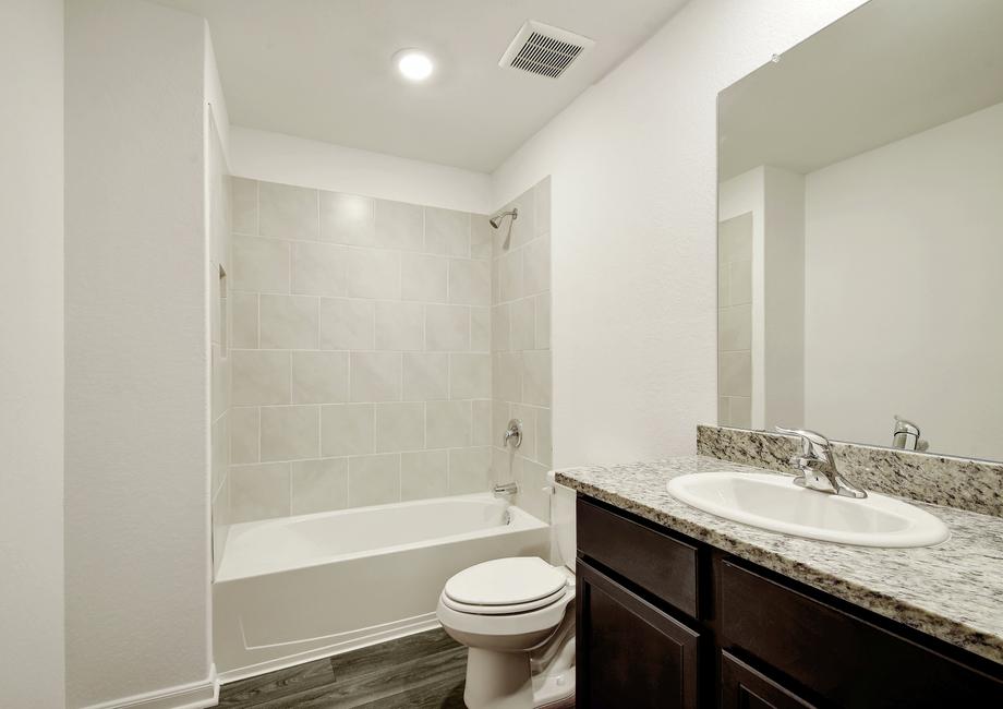 Guest bathroom with a dual shower and bath tub.