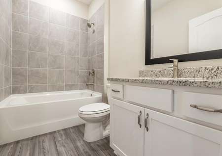Secondary bathroom with granite countertops and modern hardware.
