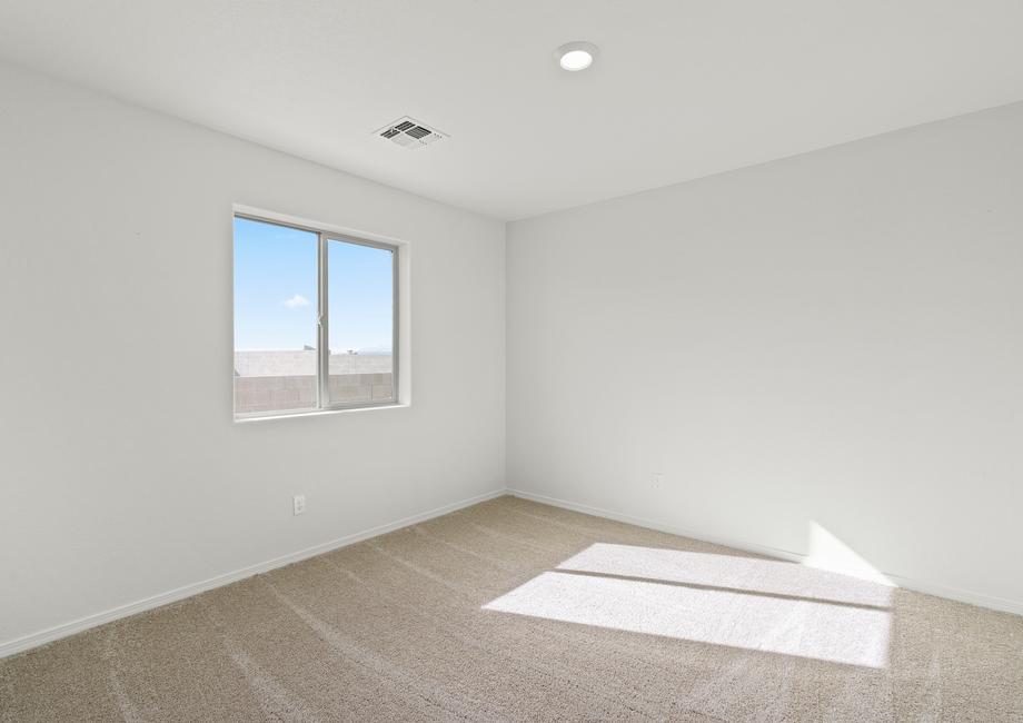 Guest bedroom with windows and tan carpet.