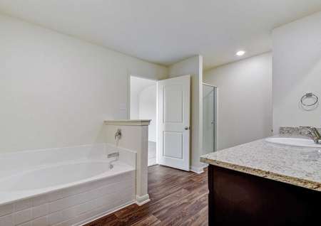 Rio bathroom with canned light fixtures, granite countertops, and brown cabinetry