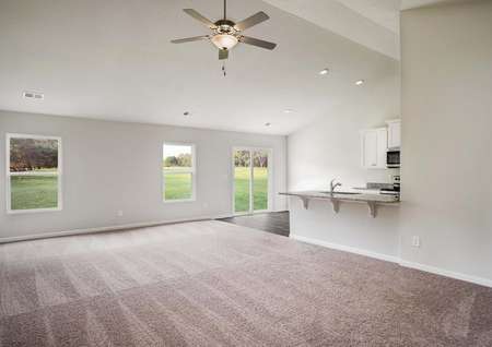 Open concept floor plan with a large living room featuring a ceiling fan.