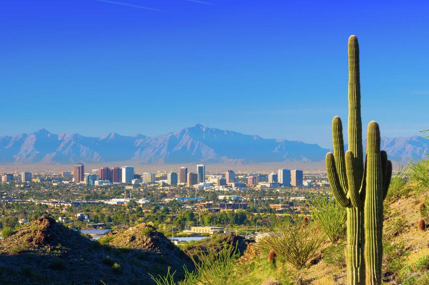 Phoenix, Arizona skyline with saguaro cacti, city skyscrapers, and South Mountain in the background
