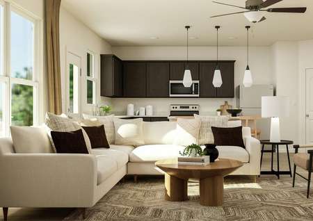 Rendering of the open layout of the
  Jaguar floor plan, featuring living room furniture and a view of the kitchen
  in the background.