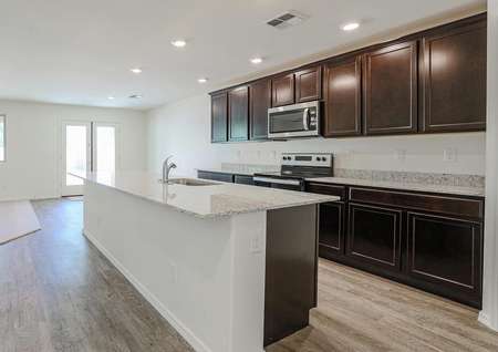 Upgraded kitchen showcasing espresso cabinets with crown molding and a full suite of stainless steel appliances.