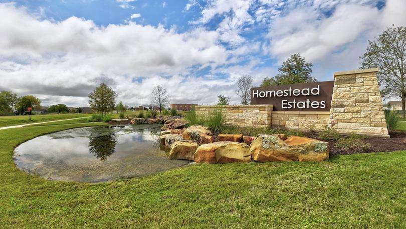 Homestead Estates monument sign adjacent to a pond