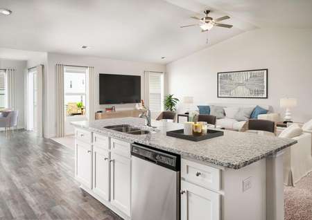 Staged kitchen and living room with granite countertops.