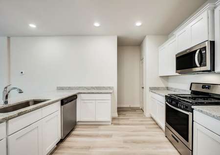 Stainless steel appliances, luxurious granite countertops and white cabinets fill the heart of the home.