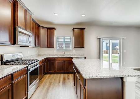 Roosevelt kitchen with granite counters, stainless steel appliances, and dark wood cabinets