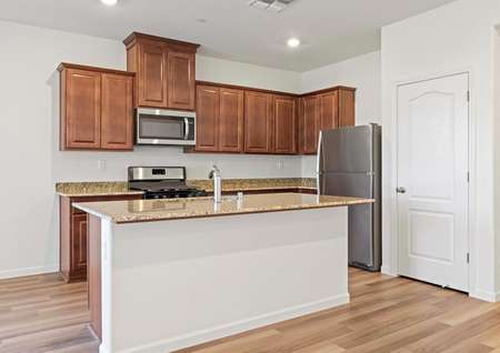 The kitchen has stainless steel appliances and plank flooring. 