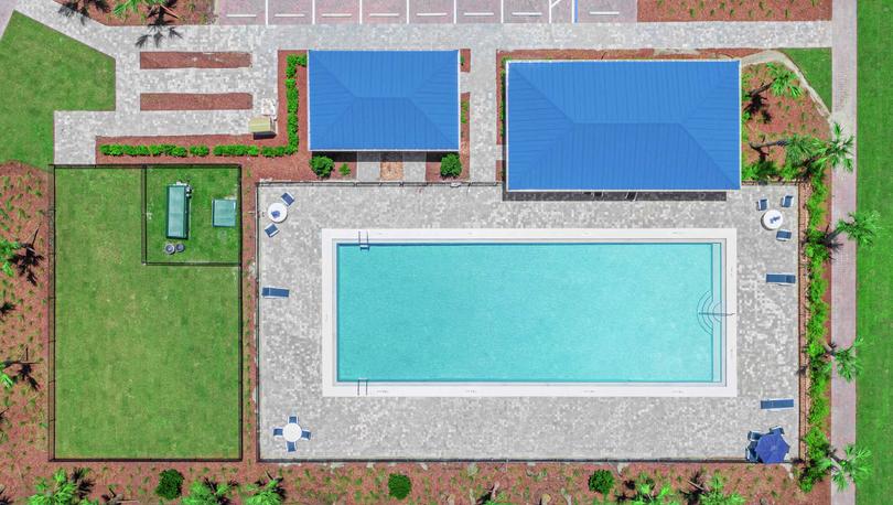 Aerial drone shot of the community pool, covered pavilion, open spaces and amenities at Celebration Pointe