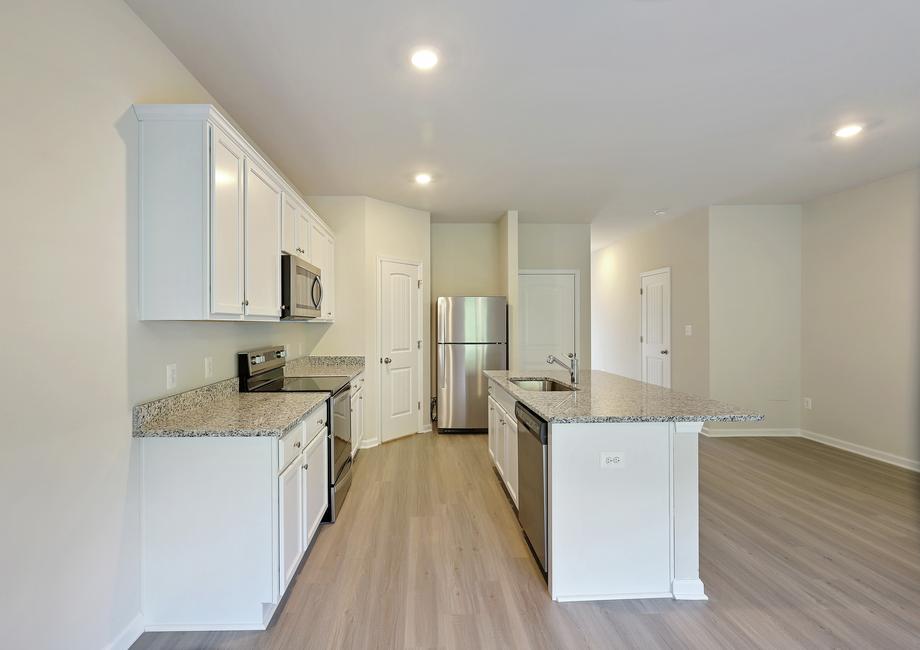 Kitchen with white cabinets and vinyl flooring.