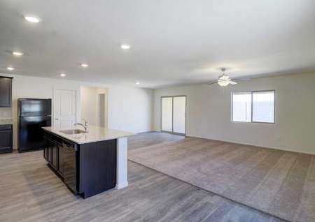 The Picacho floor plan living, dining and kitchen area with granite countertops and black appliances in the kitchen.