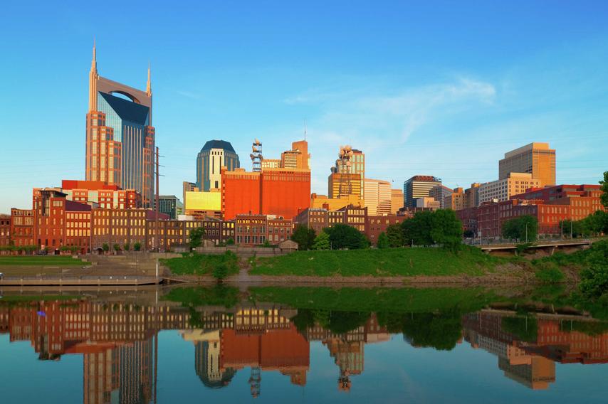 Nashville, Tennessee city buildings showing the still Cumberland River, industrial buildings, and tall skyscrapers