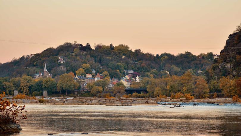 Martinsburg, West Virginia River to the Lower Township of Harpers Ferry at first light with flowing waters, trees, and town buildings