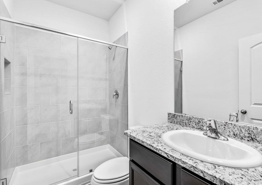 Guest bathroom with a walk-in shower that is lined with tile.