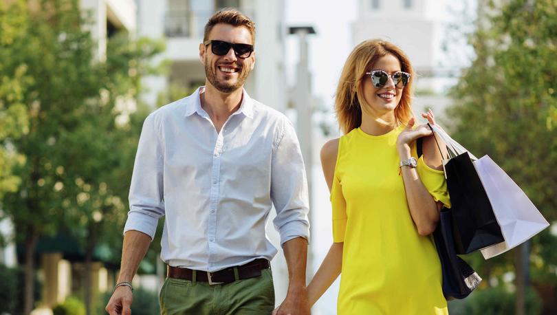 Couple with shopping bags walking and holding hands.