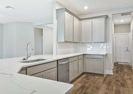The kitchen has beautiful grey cabinets and quartz countertops