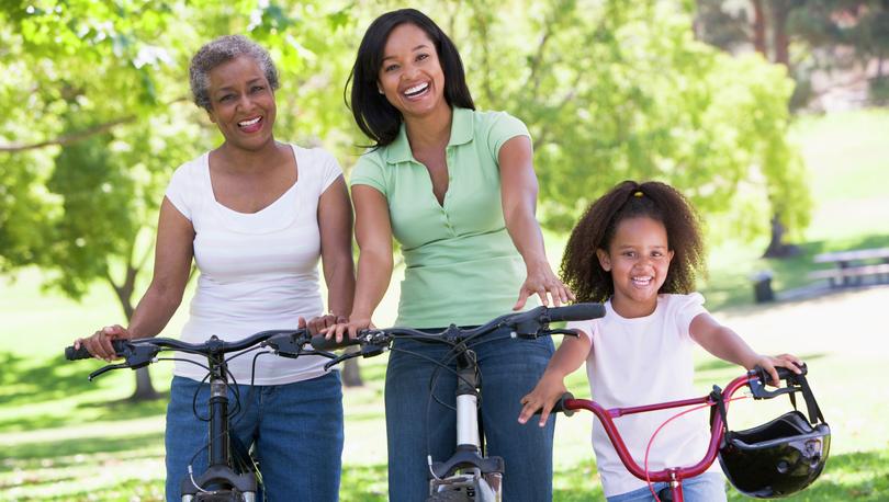 Family smiling while on bicycles.