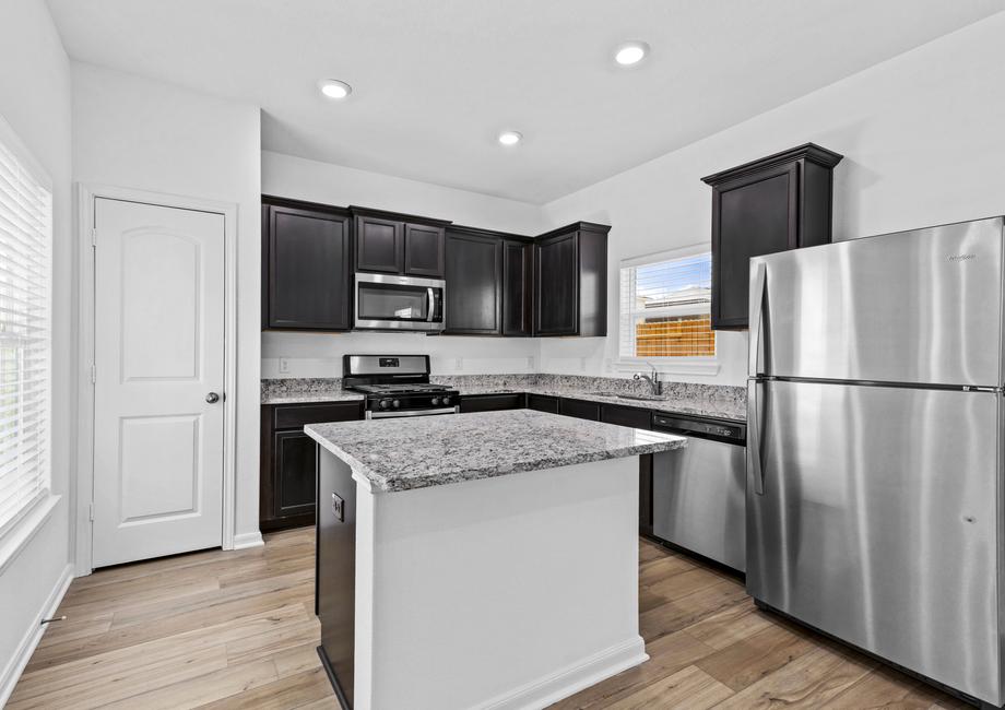 Designer kitchen with stainless appliances, granite countertops, and recessed lighting.